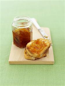 Orange marmalade on bread and in jar