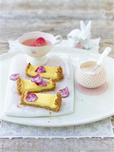 Three pieces of white chocolate tart, candied rose petals