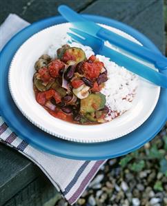 Vegetable stew with rice on a wooden table out of doors