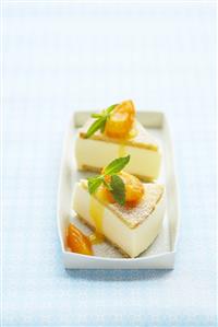 Two pieces of cheesecake with apricot compote