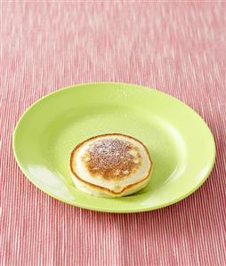 An apple pancake sprinkled with icing sugar