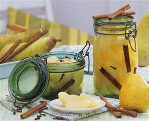 Bottled pears in preserving jars, fresh pears, spices