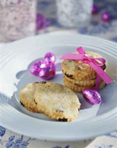 Biscuits tied with bow & chocolate Easter eggs on a plate