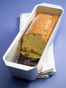 Banana cake, slices removed, in a terrine dish