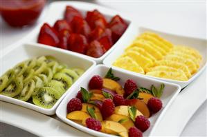 Dishes of different sliced fruits for breakfast