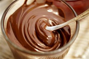 Hazelnut chocolate spread in a glass with spoon