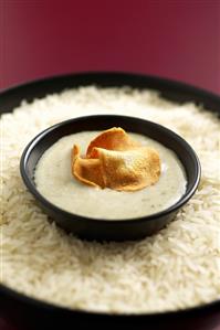 Jerusalem artichoke soup and crisps in bowl on rice