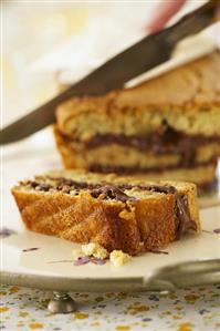 Banana cake filled with chocolate spread, partly sliced