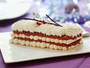 Layered meringue cake filled with fruit puree