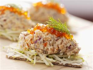 Fish tartare with salmon caviar on apple and crispbread