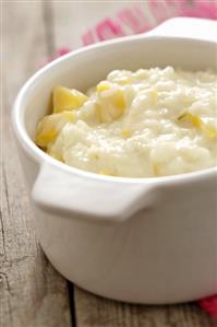 Mango risotto with coconut milk in a ceramic pot