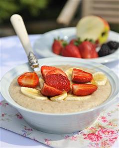 Cinnamon porridge with fresh strawberries & banana in bowl