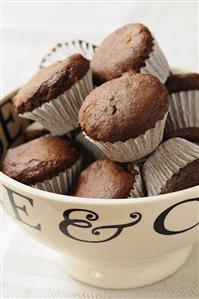 Mini chocolate muffins in paper cases in a bowl