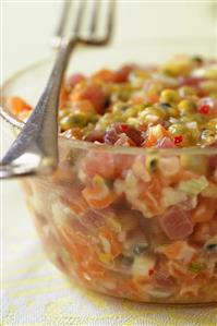 Salmon and tuna tartare with fruit in a glass bowl