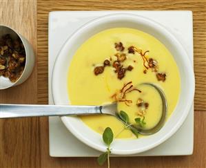 Cream of potato soup with bacon, saffron, caramelised nuts