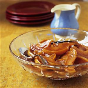 Quince compote in a glass bowl with a small jug of cream