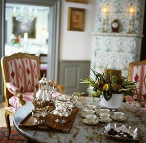 Tray, silver teaset, cups & saucers & chocolates on table