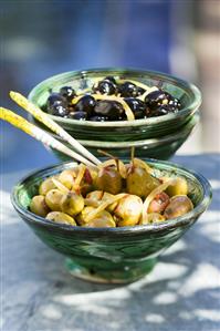 Olives preserved in olive oil with herbs, spices, lemon