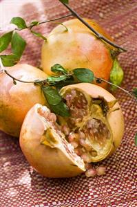 Pomegranates, two whole and one halved