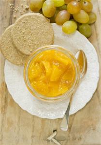 Mango & ginger chutney in a jar with oat biscuits, grapes