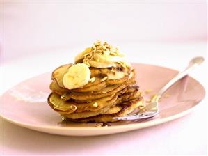 Stack of pancakes with banana slices and honey