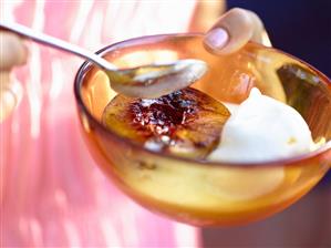 Woman holding dish of dessert (grilled peach half & ice cream)