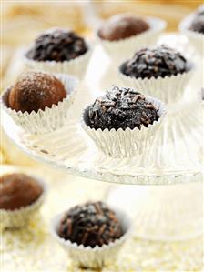 Assorted chocolate truffles on and beside a cake stand