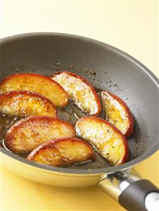 Caramelised apple slices in a frying pan