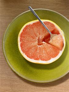 Half a grapefruit with a spoon