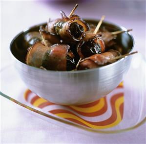 Bacon-wrapped prunes in a small bowl