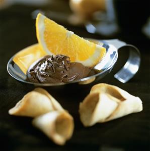 Chocolate cream with orange wedge and wafers