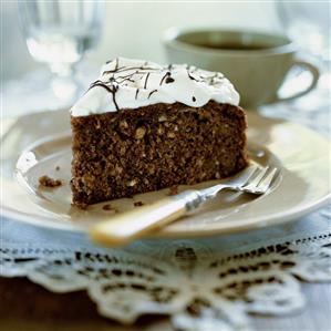 A piece of chocolate and nut cake with whipped cream