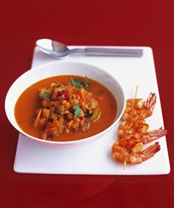 Tomato, lentil and chilli soup with fried prawn skewer