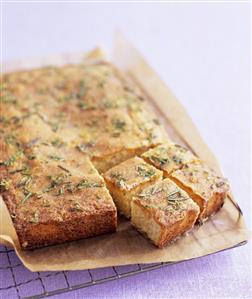 Lemon and rosemary cake on a baking rack