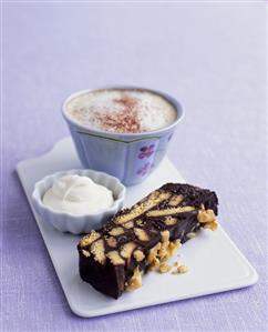 A piece of chocolate biscuit cake with walnuts