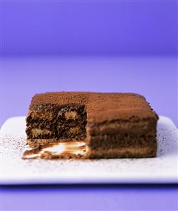 Chocolate tiramisu, a portion removed, on a platter