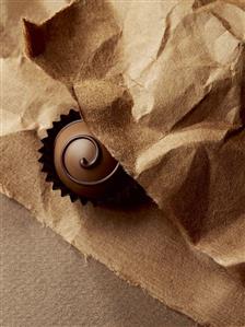 A chocolate on brown paper