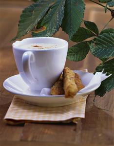 Cauliflower soup in cup with breaded white sausage sticks