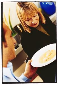 Man passing home-made gingered monkfish soup to a woman