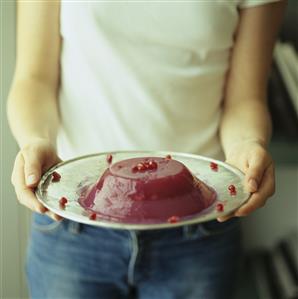 Young woman holding pomegranate jelly