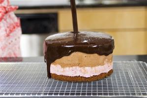 Pouring couverture chocolate over a cake