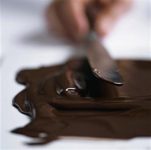 Spreading melted chocolate on a work surface