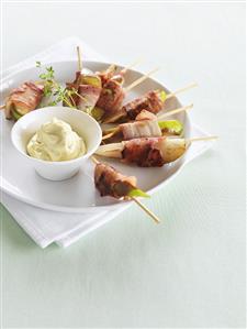 Bacon-wrapped pear wedges on cocktail sticks, cheese dip