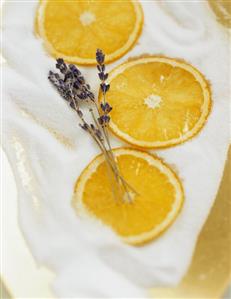 Slices of orange and lavender flowers on sugar