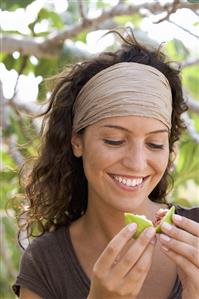 Woman breaking open a fresh fig