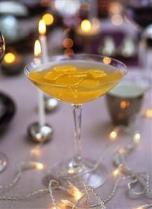 Sparkling wine & peach cocktail with orange juice ice cubes