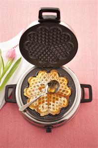 Lemon waffle with maple syrup in waffle iron