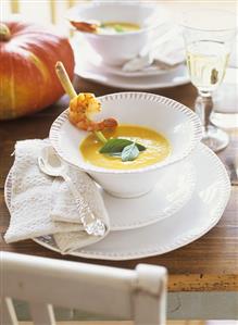 Pumpkin & coconut soup garnished with prawn on lemon grass