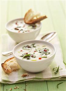 Two bowls of cream of kohlrabi soup with ramsons & white bread