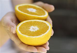 Hands holding a halved grapefruit